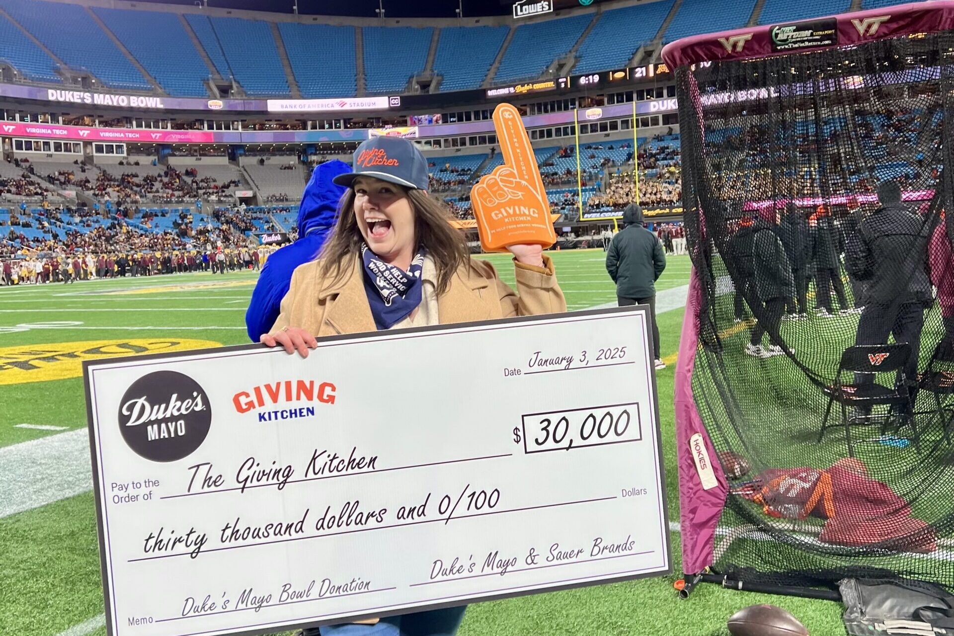 Giving Kitchen accepts a check at the Duke's Mayo Bowl