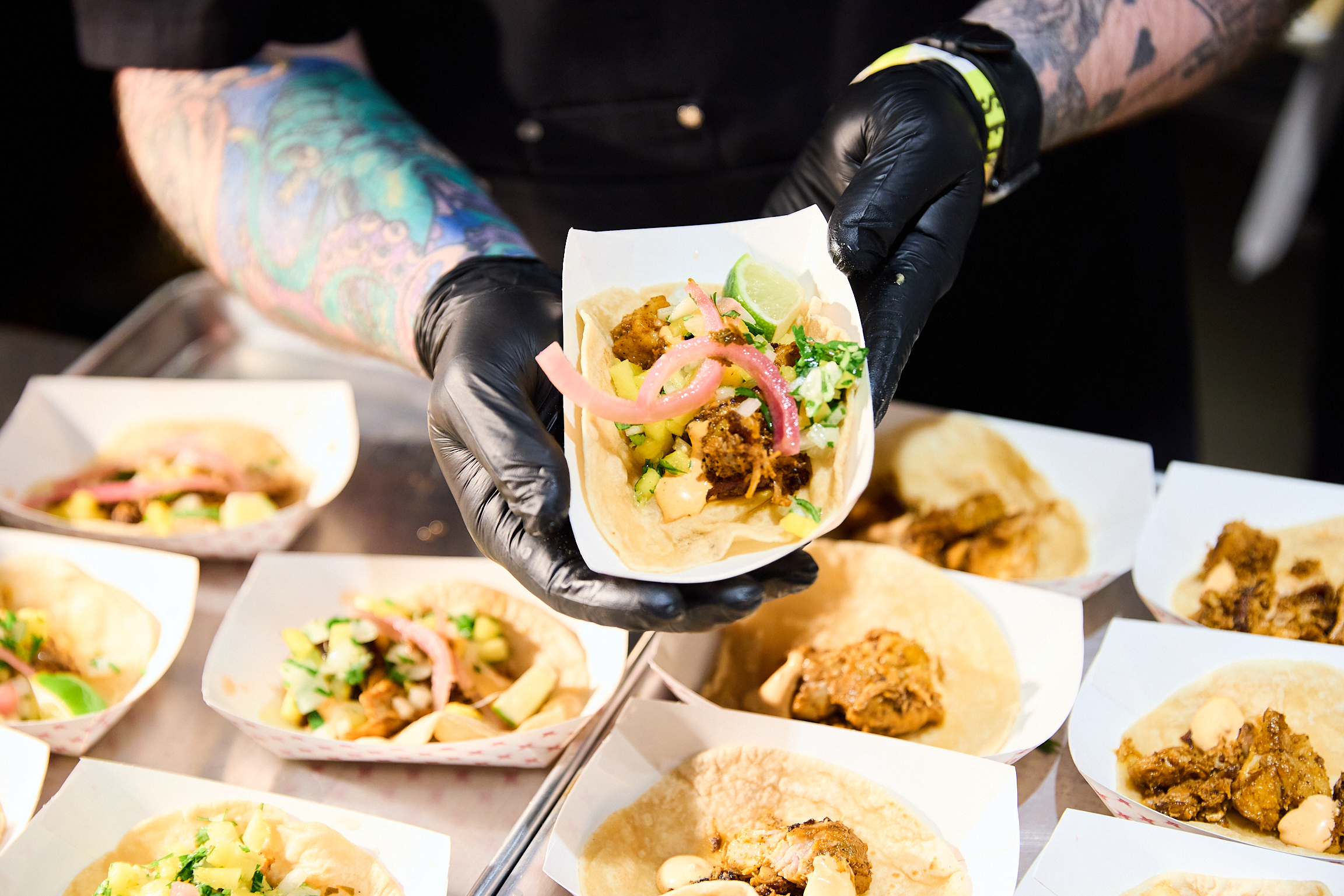 Chef holds up a taco at Team Hidi
