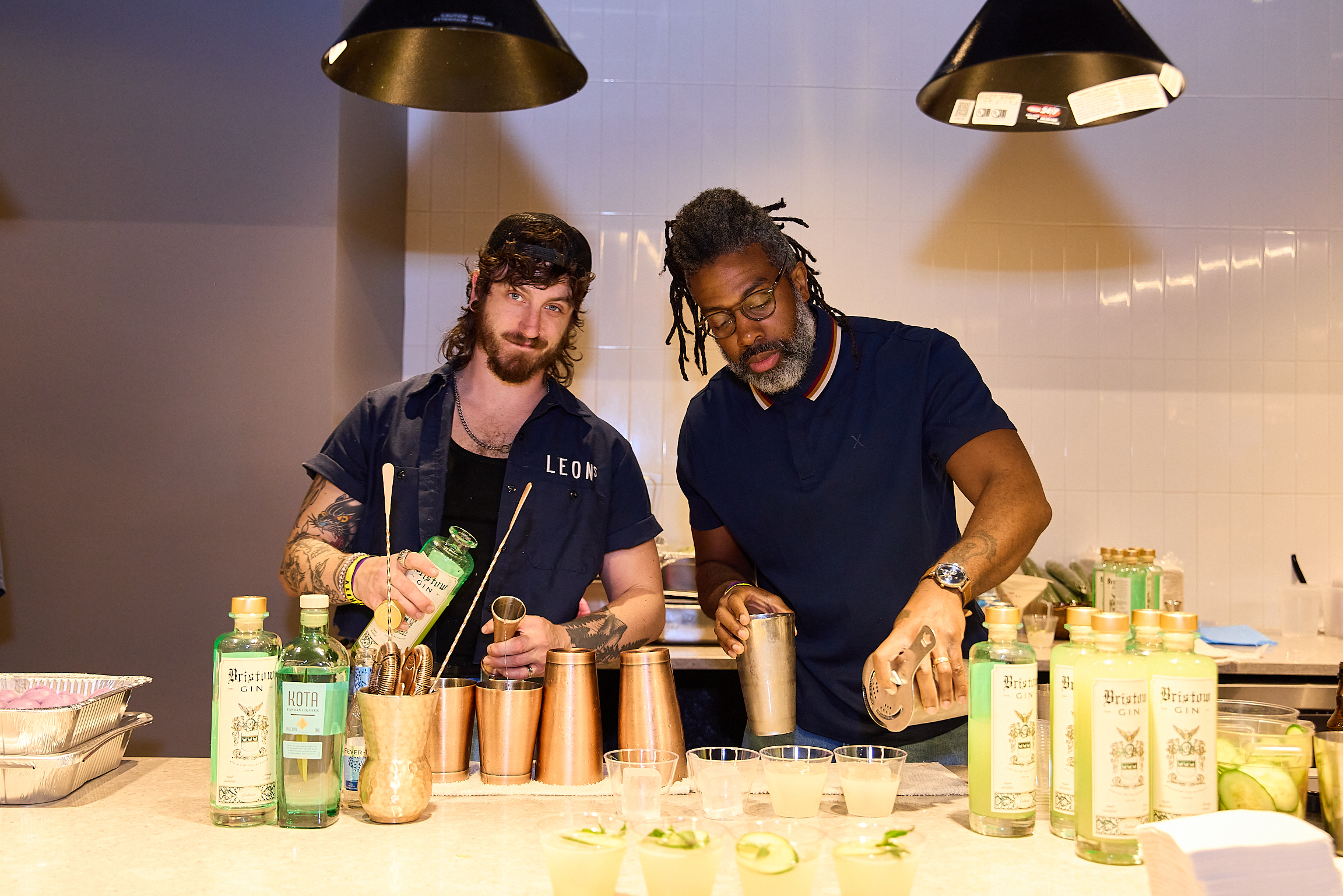 Bartenders from Leon's Full Service mix drinks at Team Hidi