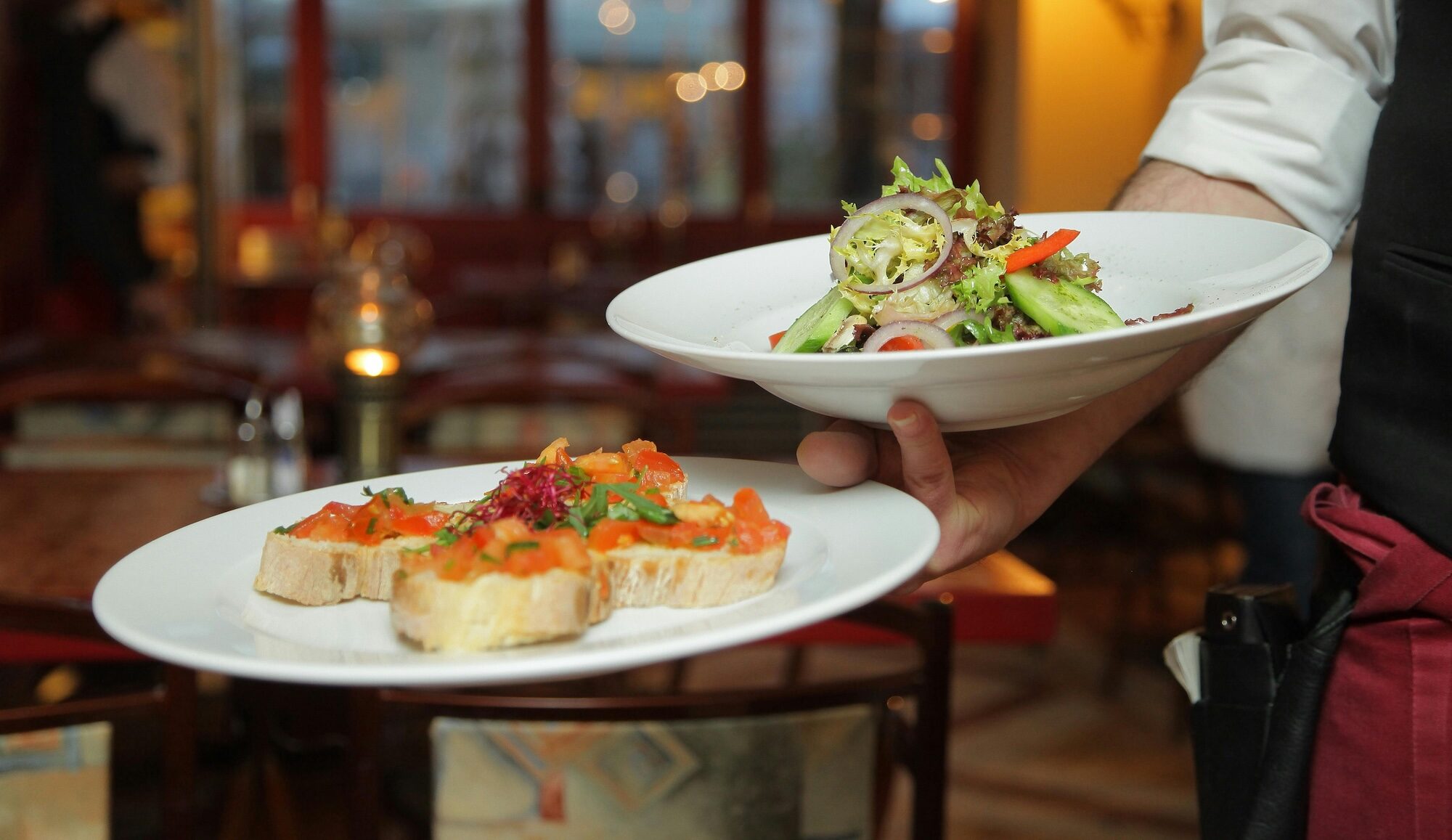 Server carries plates of appetizers