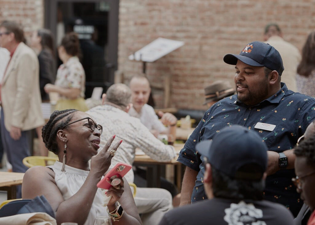 Two guests have a conversation at a Giving Kitchen event