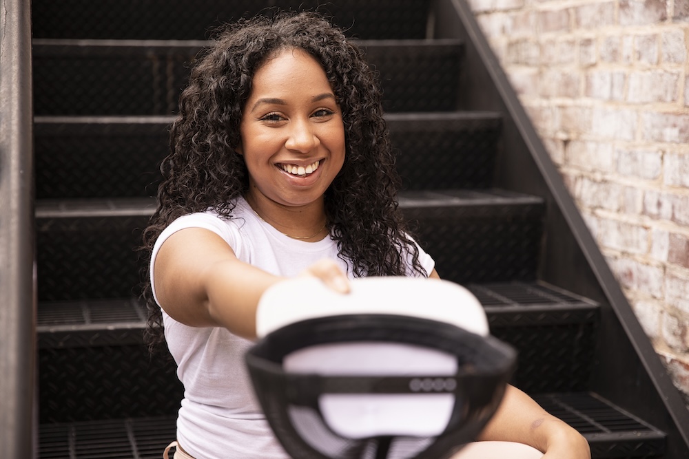 Giving Kitchen client Lexi holds out a hat